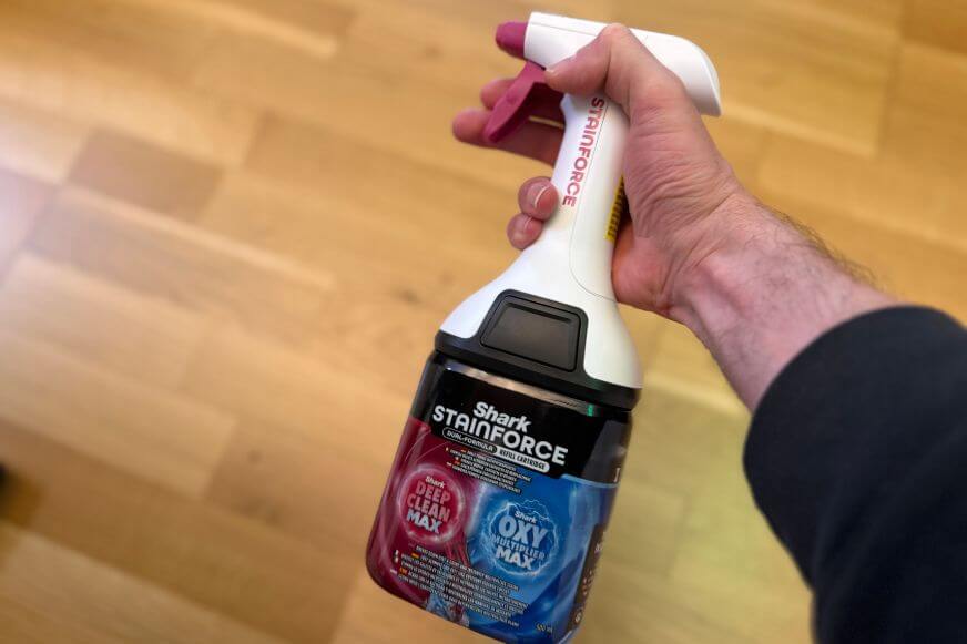 Mit der separaten Shark Stainforce Sprühflasche wird der Fleck vorbehandelt und eingesprüht.